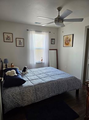 Montrose apartment for rent - A bedroom with a bed, a ceiling fan, and pictures on the wall.